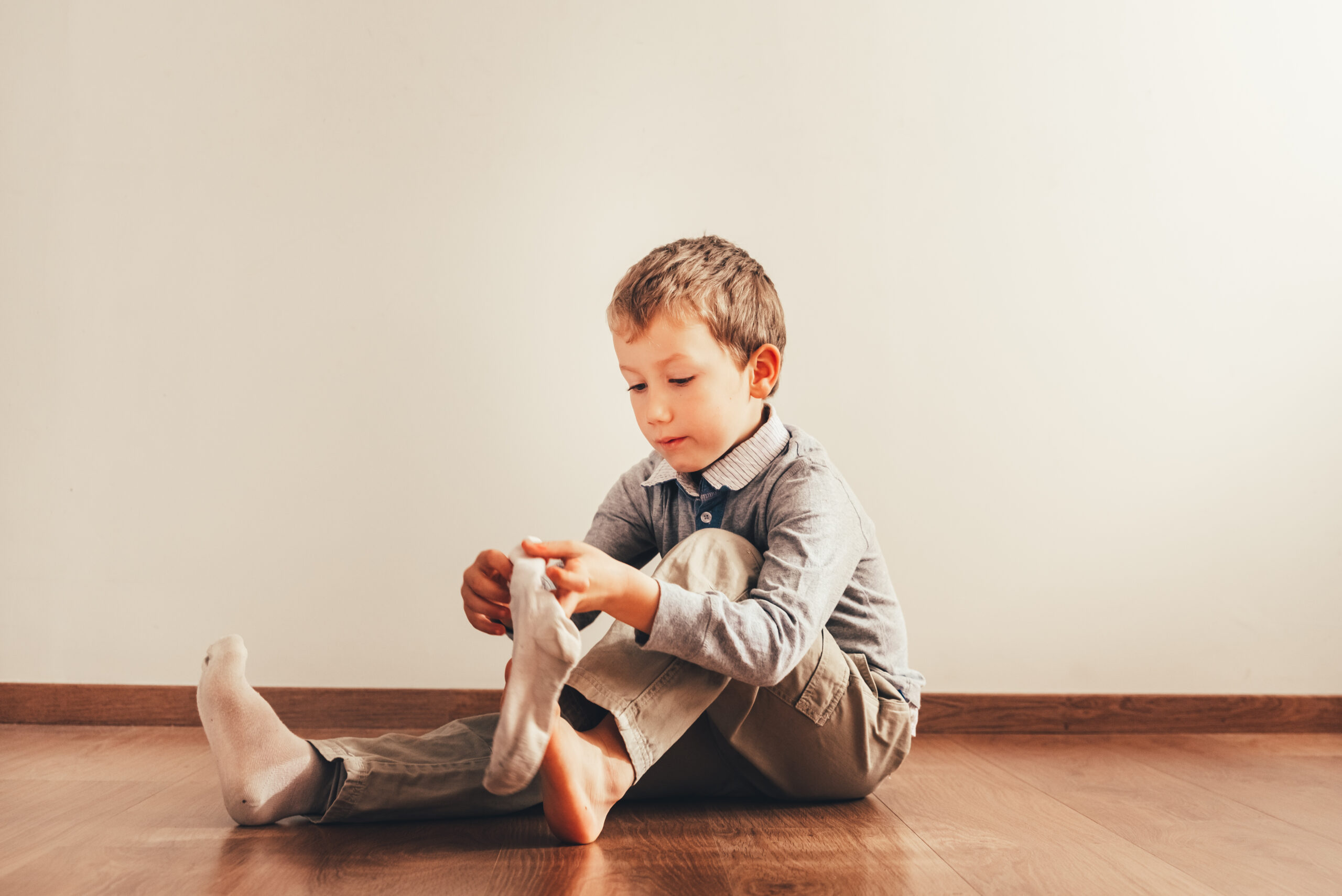 Niño vistiéndose el solo sin tener ayuda de sus padres.